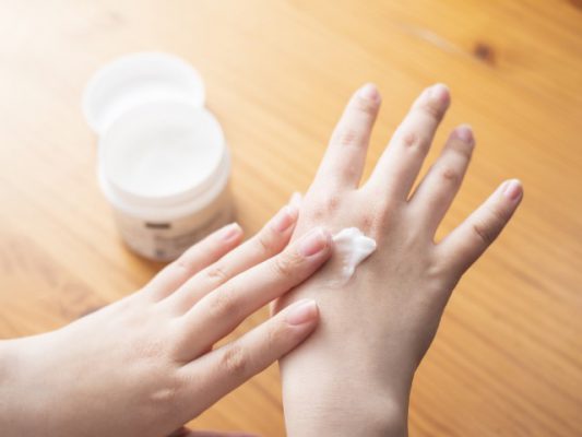 スパサロンの女性客の手をマッサージする美容師 プロの男性マッサージ師が若い女性の手を揉むPremium写真