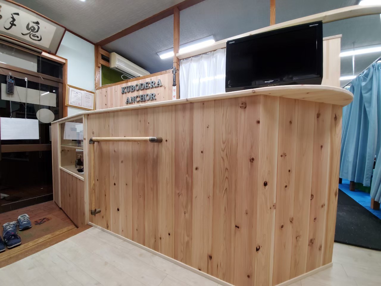 受付カウンターの間接照明が温かい雰囲気を演出する鍼灸整骨院整骨院・治療院専門の内装フルサポキュア