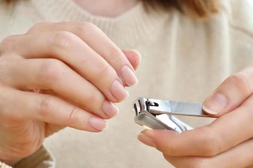 爪切りで爪を切る女性の手元 10521005334 の写真・イラスト素材アマナイメージズ