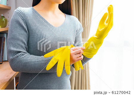 家事をする前に保護ゴム手袋をはめた女性の接写。家で掃除する準備ができている間にピンクの手の保護具を身に着けている女性のメイドの手に焦点を当てます。家事のコンセプトの写真素材・画像素材Image 193132396